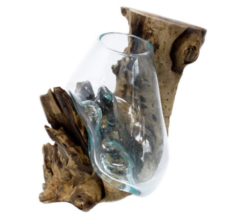 A glass vase shaped like a wine glass, supported by a piece of driftwood.